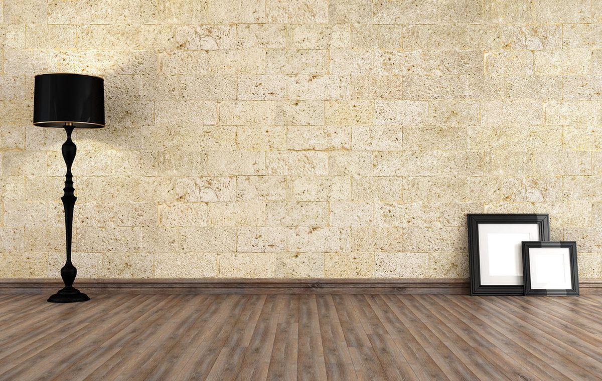 Innenraum mit Holzdielenboden vor einer Natursteinwand